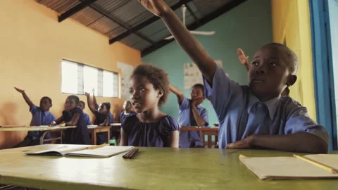 4k Front view of African pupils / students raising hand in class to answer teach Stockbeeldmateriaal 199625635