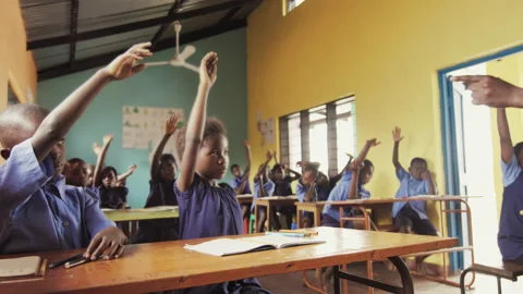 4k Front view of African pupils / students raising hand in class to answer teach Vidéo 199625772