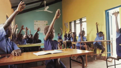 4k Front view of African pupils / students raising hand in class to answer teach Stockbeeldmateriaal 199625794
