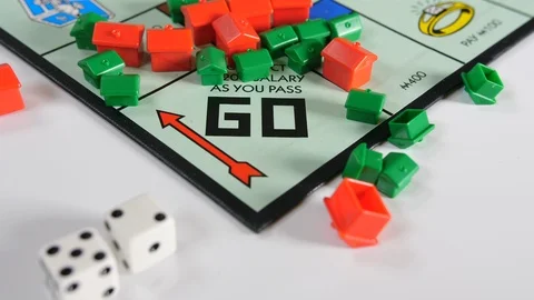 4K game board game with plastic house shapes and rolling dice, red and white  Stock Footage 90786779