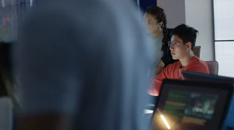 4K Game designers looking at computer screen &amp; discussing ideas for the project Stock Footage 67568439