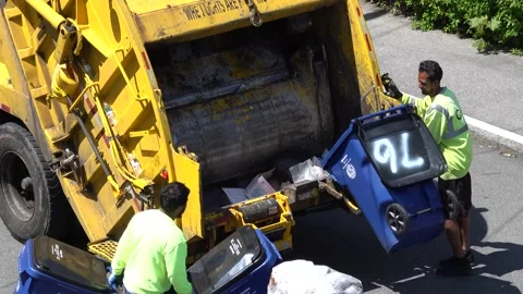 4K Garbage truck men empty rubbish trash barrels using automatic lifters Stock Footage 130968760