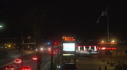 4K: Giant US Flag waves under a dark sky as light traffic pass on the street Stock Footage 63085980