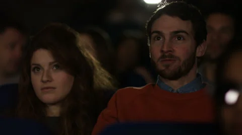 4K Girl looks uncomfortable when her date puts arm around her in crowded cinema Stock Footage 59672318