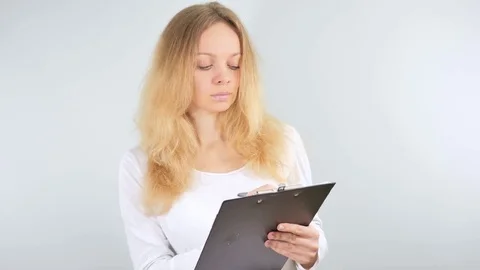 4k. Girl taking notes in the tablet. Isolated on white background. Mockup Stock Footage 81476764