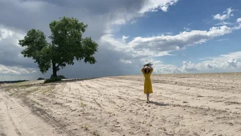 4k Girl walking on an empty field with a bouquet of wildflowers. Stock Footage 156980128