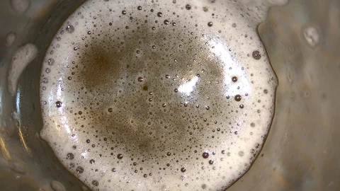 4K Glass of beer with bubbles top view. Beer foam bubbles closeup Stock Footage 105773479