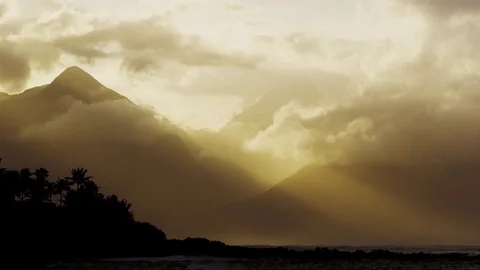 4K: God Rays beaming through Mountainside Meeting Ocean/Sunset Stock Footage 72996806