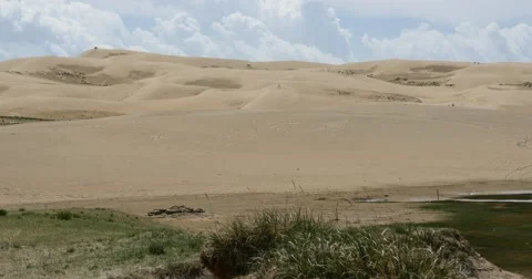 4k great white puffy cloud mass rolling over desert sand dunes. Stock Footage 43512731