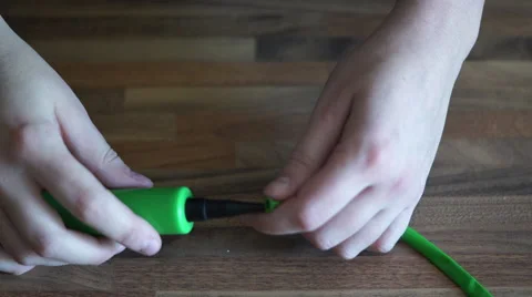 4K a green balloon pump breaks while pumping a balloon animal up Stock Footage 55287466