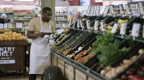 4K Grocery store worker checking fresh produce &amp; using tablet computer Stock Footage 64901880
