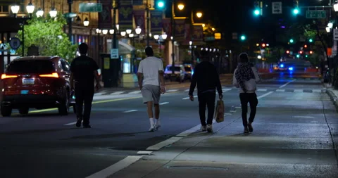 4K GROUP OF FOUR MEN WALKING ON ABANDONED CITY STREET DURING CURFEW Video stock 132602955