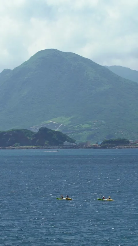 4K, Group of people rows an outrigger canoe on ocean with beautiful mountain Stock Footage 312114301