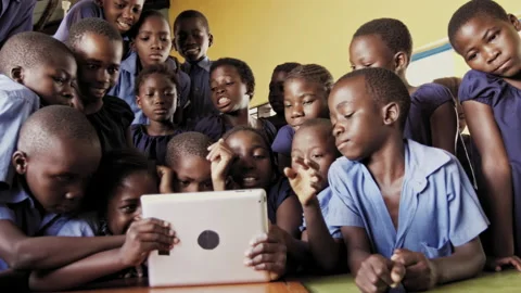 4k of group of pupils viewing a touch screen tablet computer in African classroo 動画素材 199625308