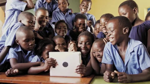 4k of group of pupils viewing a touch screen tablet computer in African classroo Vídeos de archivo 199625311