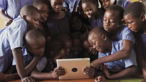 4k of group of pupils viewing a touch screen tablet computer in African classroo Видео 199625327