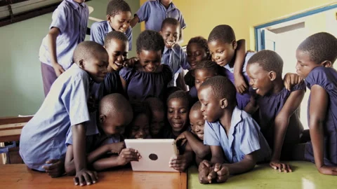 4k of group of pupils viewing a touch screen tablet computer in African classroo Stock Footage 199625402