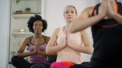 4K Group of women doing stretches & meditating in yoga class Stock Footage