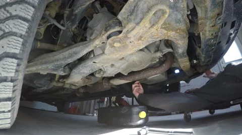 4k guy changes his oil under car Video stock 61417211