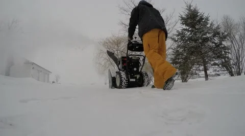 4k guy snowblowing snow with unique angle Stock Footage 46502049