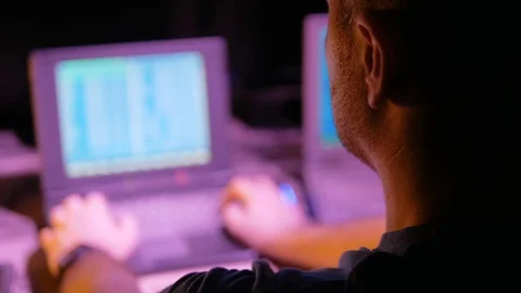 4k Hacker develops software and virus at retro laptop in dark room with neon  Video stock 86206315