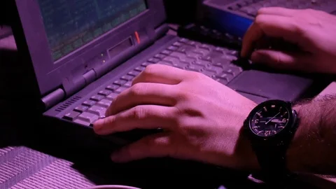 4k Hacker works with old retro laptops at dark room with neon light  hands close Stock Footage 86206193
