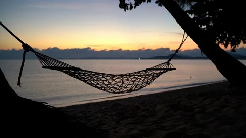 4K hammock hanging from two palm trees on background of sunrise Stock-Footage 114743600