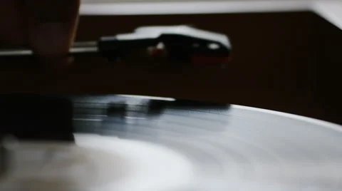 4K Hand putting a record player needle down onto a spinning record, in slow moti Video stock 64208525