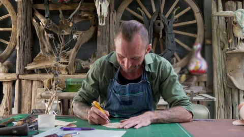 4K, Handcrafted leather worker sits farts cowhide with cutter according pat.. Stock Footage 234069965