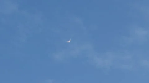 4K Handheld shot of moon against the blue sky with clouds moving  Stock Footage 323008973