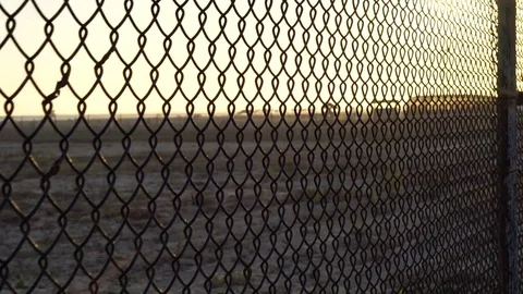 4K Handheld shot walking along fence. Stock Footage 77574677