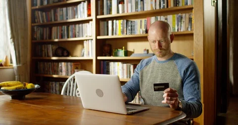 4k handsome young man using his laptop at home Stock Footage 128354974