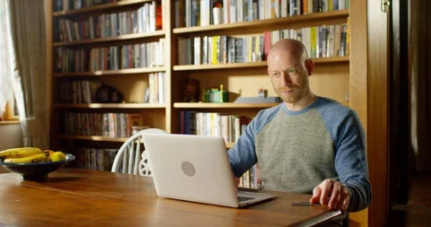 4k handsome young man using his laptop at home Stock Footage 128355802