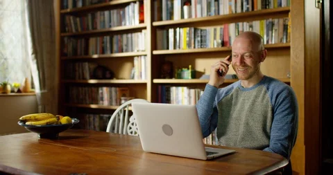 4k handsome young man using his laptop at home Stock Footage 128357965