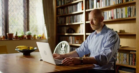 4k handsome young man using his laptop at home Stock Footage 128358773