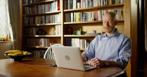 4k handsome young man using his laptop at home Stock Footage 128359989