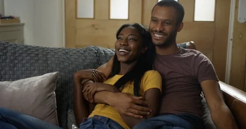 4K Happy affectionate couple relaxing at home, watching something funny on TV Stock Footage 82298907
