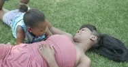 4K Happy African American Mother, Daughter Lying Down, Talking In The Park Stock Footage