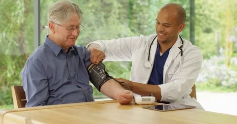 4k, A happy and cheerful doctor checking a senior patient's blood pressure. Stock Footage