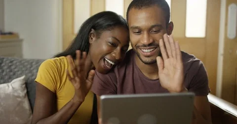 4K Happy attractive couple making a video call at home on computer tablet Stock Footage 82327356