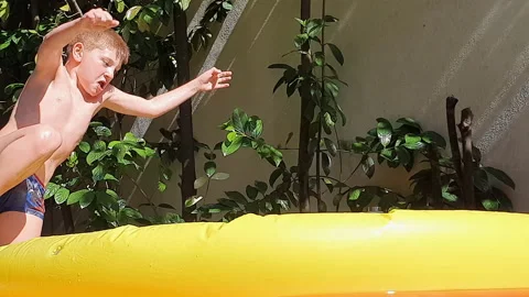 4K Happy boy slow motion jumping in slow motion in a swimming pool Stock Footage 134540624