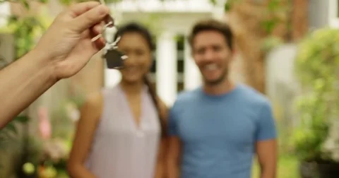 4K Happy couple in front of new home, taking the key from real estate agent Stock Footage 80473281