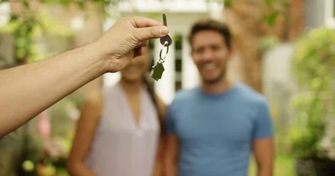 4K Happy couple in front of new home, taking the key from real estate agent Video stock 80578464