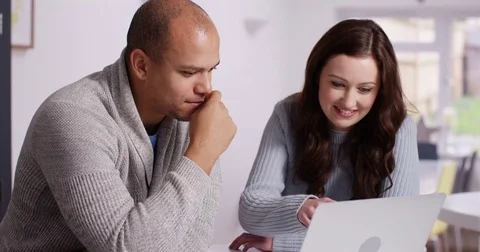 4K Happy couple at home looking at laptop &amp; laughing at what they see on screen Stock Footage 71695283