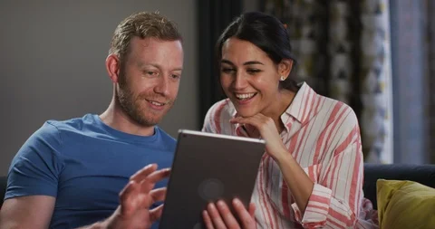 4K Happy couple looking at computer tablet together at home Stock Footage 108796304