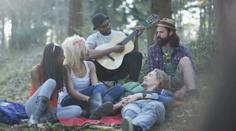 4K Happy hipsters camping in the woods, one man tells a story to his friends Stock Footage