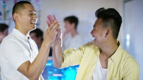 4K Happy male computer programmers working together give a high five Stock Footage 54473301