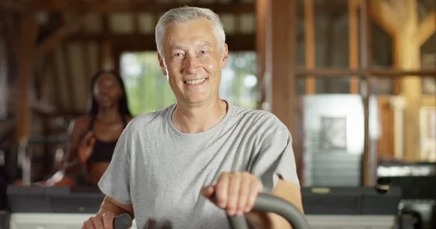 4K Happy mature man working out at health club &amp; smiling at camera Stock Footage 94837876