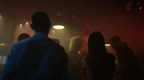 4K Happy party crowd dancing in nightclub with 2 girls dancing on the bar. Stock Footage 64613020