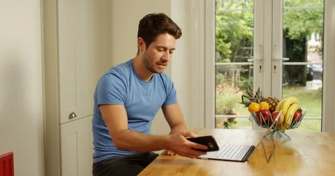 4K Happy professional man working from home, using computer &amp; making phone call Stock Footage 80564436